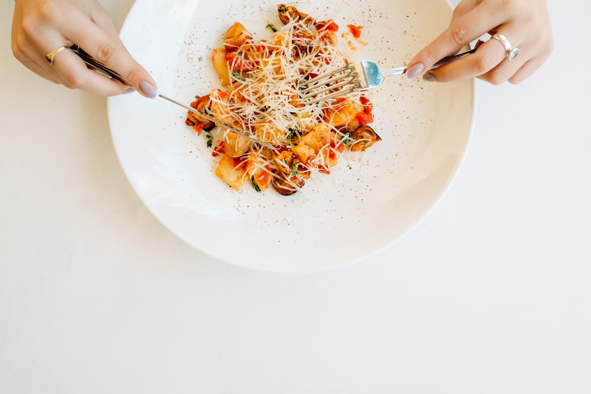 Close-up of hands plating food during online class